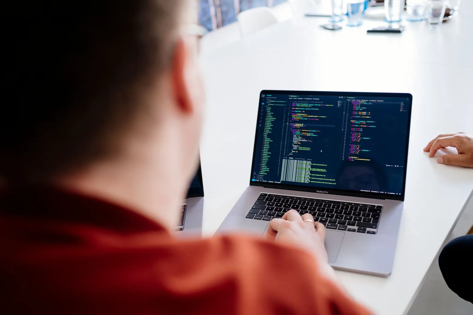 Mitarbeiter der an einem Laptop ein Programm zum Coden einer Webseite bedient.